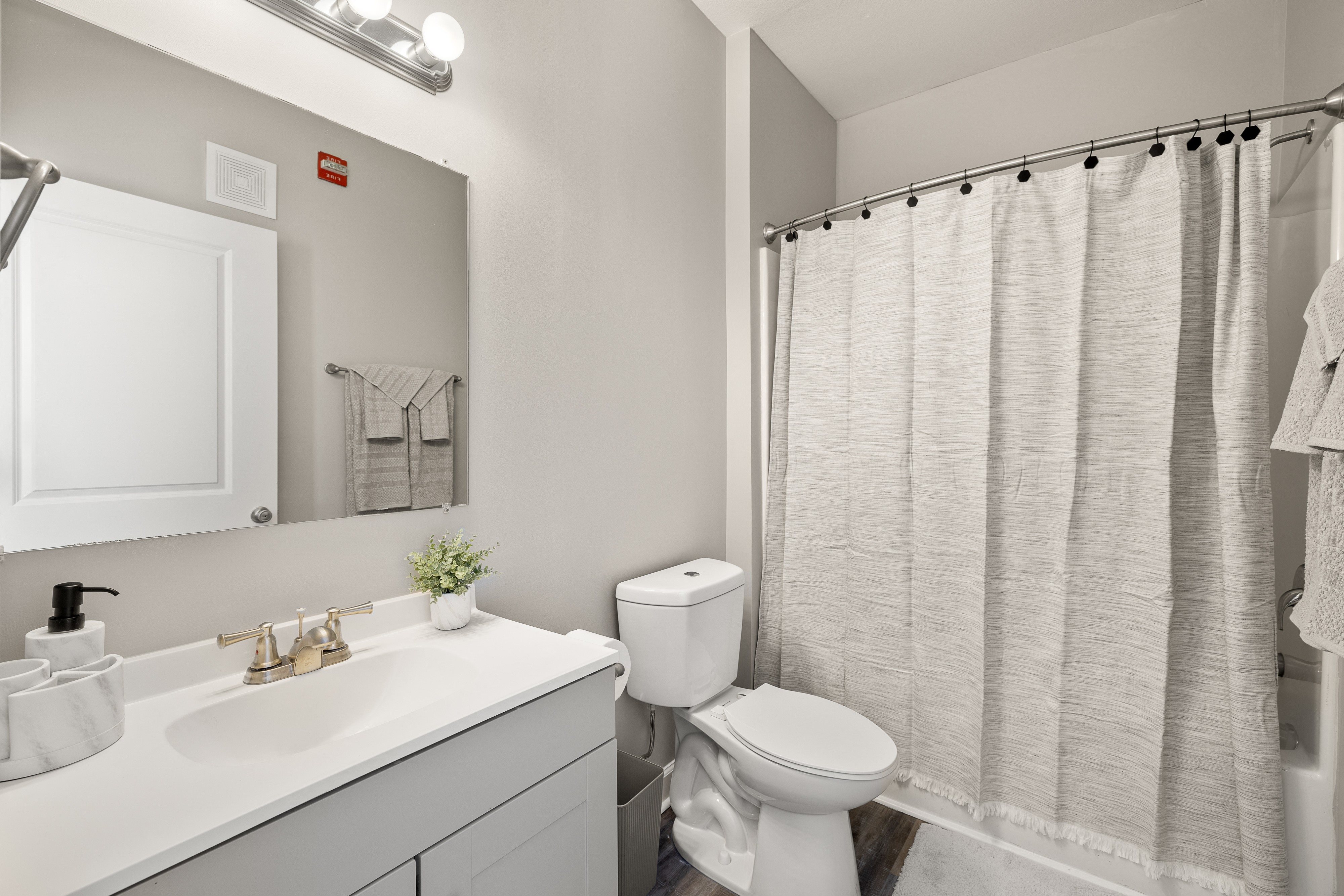 a bathroom with a shower and a toilet and a sink
